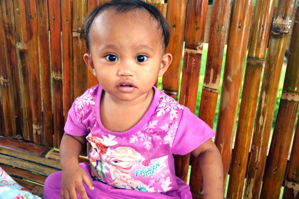This is one of VOH's newest kids. · Her mother is an 18-year-old rape victim · Her grandmother is 39 years old and has 13 kids · She was starving, couldn't walk, and had a skin disease (scabies) and worms when rescued · She cried all the time because she is hungry · Now at VOH, she loves to sing and hum. She loves to carry her toy doll. Now, she is walking.